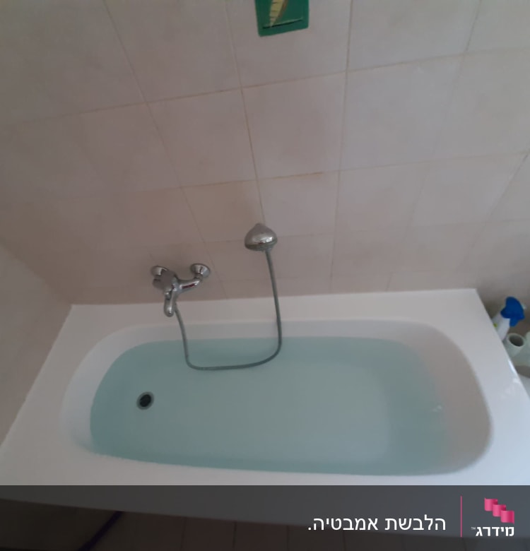 אמבטיה עם מים, ברז ומקלחת יד